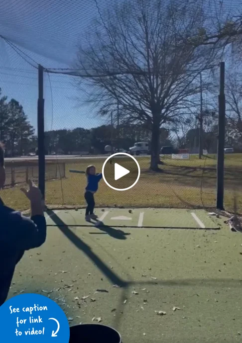 Young girl at bat on a baseball field