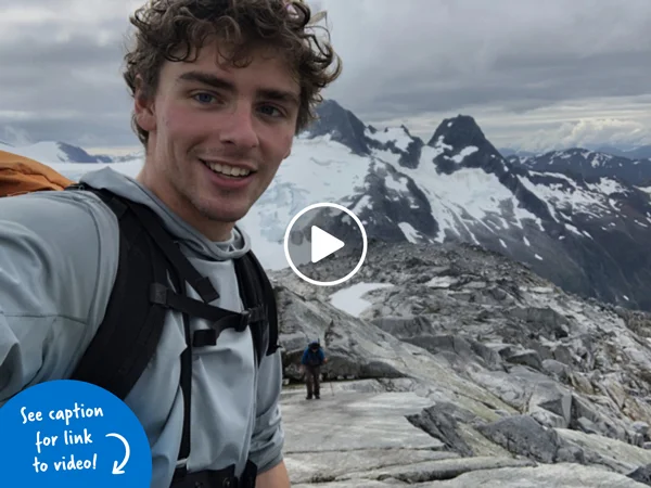 Young man smiling on a snowy mountain in Alaska