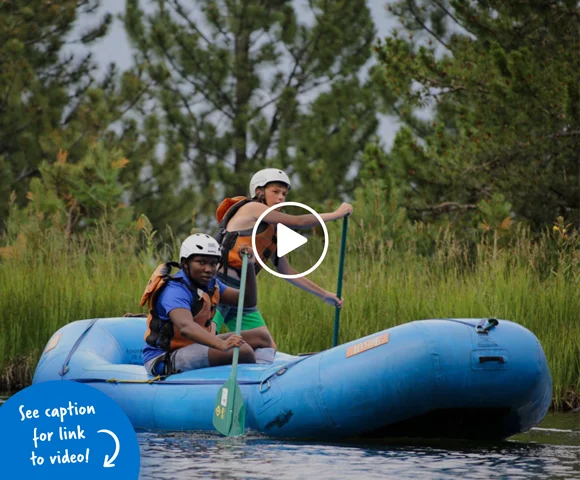 Two boys paddling a raft outdoors