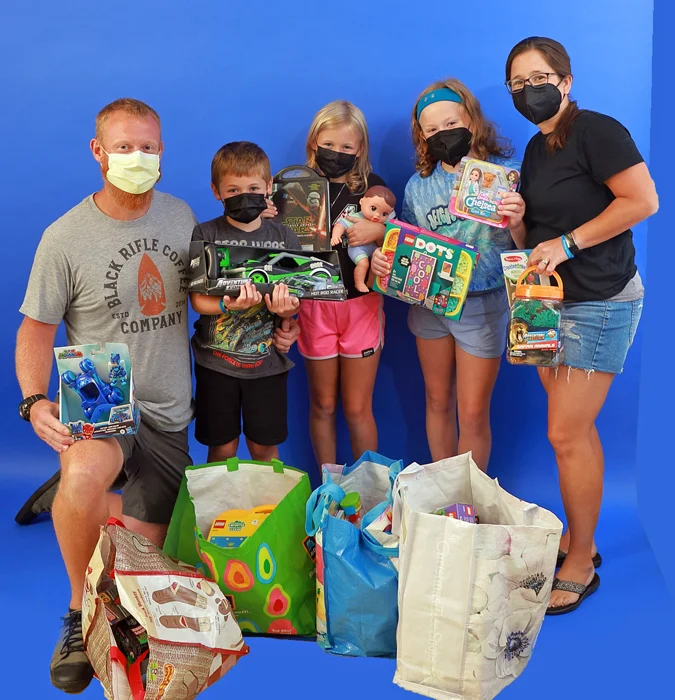 Ladoucer family members holding toys and bags of toys they donated