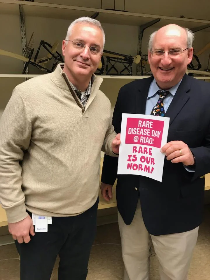 Dr. Standard and Dr. Herzenberg holding a sign for Rare Disease Day at the Rubin Institute for Advanced Orthopedics