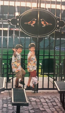 Christopher as a young boy wearing external fixator with cover with his twin at Camden Yards