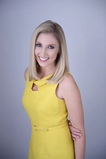 Carly's professional photograph with her standing in a yellow dress