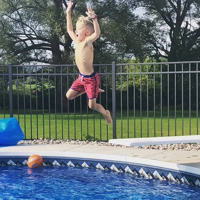 Jadon jumping high in the air at a swimming pool