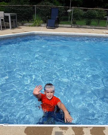 Wyatt waving while in a swimming pool waving