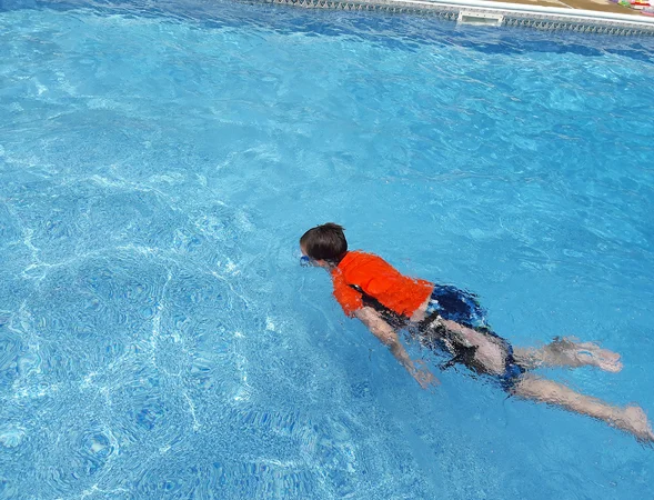 Wyatt swimming in a pool with his external fixator bar showing