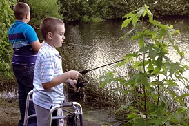 Wyatt fishing at a lake while using a walker