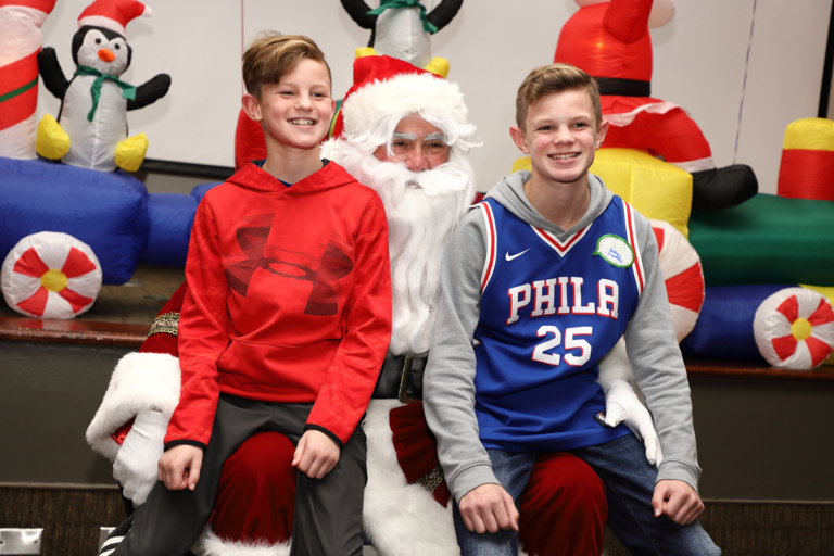 2 boys smiling on Santa’s lap