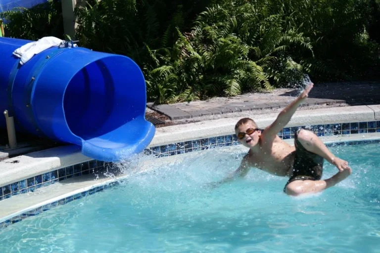 Matt in midair shooting out of a swimming pool tube slide before his second surgery