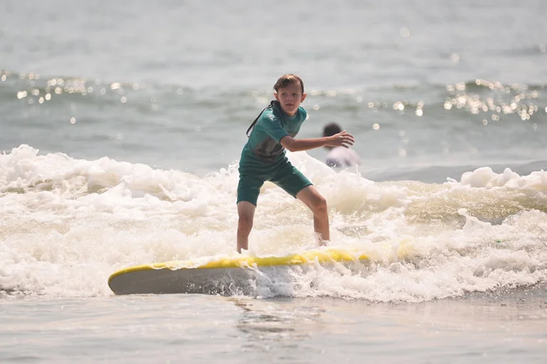 Jeffrey at 10 surfing on a surf board in the ocean