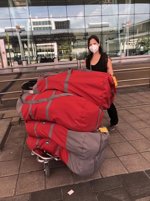 Merrill Chaus Herzenberg standing with 200 pounds of medical supplies that she took to earthquake-stricken Haiti