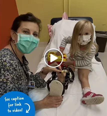 A woman performing physical therapy on a little girl with an external fixator on her leg