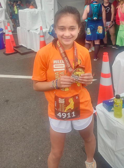 Aria with her finishing medal from a race