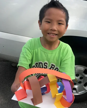 James smiling showing an intricate art project he completed