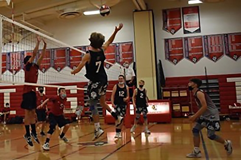 Josh jumping up for a volleyball in a gym