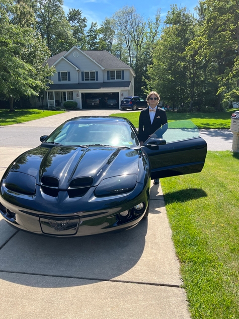 Josh dressed up for a prom with a sports car