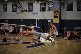 Josh diving for a volleyball in a gym