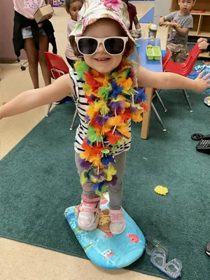 Riley at school playing dress up on a surf board